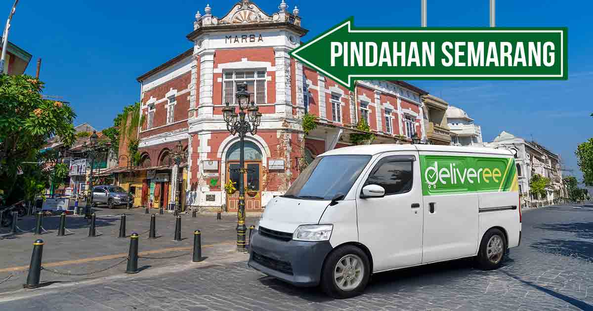 Mobil Deliveree parkir di depan bangunan bersejarah di Semarang dengan papan arah bertuliskan "Pindahan Semarang."