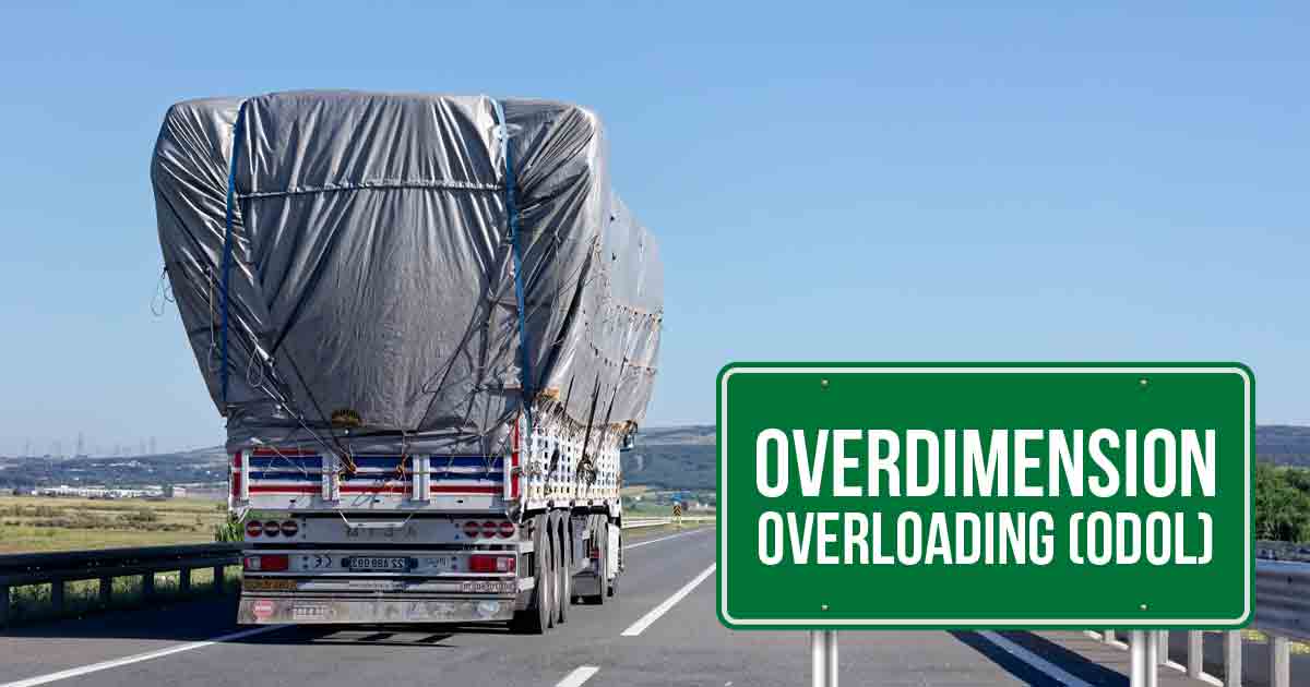 Truk ODOL (Overdimension Overloading) di jalan raya dengan muatan besar yang ditutupi terpal.